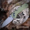 The Buck Range Ops Pro 0797GRS1 is shown open, featuring a gray Cerakote 154CM reverse tanto blade, crossbar lock, and OD green GFN handle with a deep-carry pocket clip.
