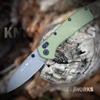 The Buck Range Ops Elite 0797GRS is shown open, featuring a gray Cerakote CPM MagnaCut reverse tanto blade, crossbar lock, and OD green aluminum handle with a deep-carry pocket clip.