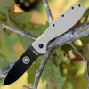The ESEE Zancudo (BRKR2DTB) shown with its 2.94-inch D2 drop point blade in a black finish and flat grind, Desert Tan polymer handle with steel frame lock, and reversible pocket clip for tip-up or tip-down carry.