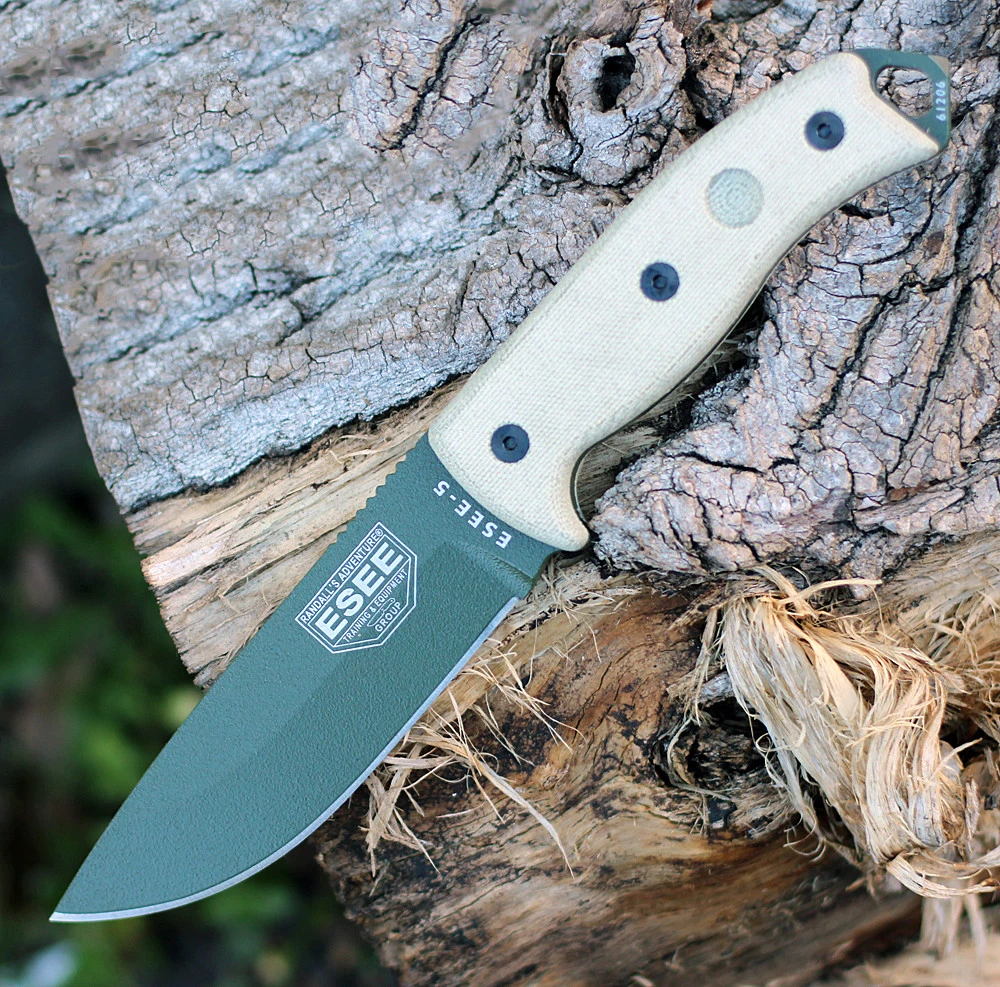 The ESEE-5 (ESEE-5P-KO-OD-E) shown with its 5.25-inch 1095 saber ground drop point blade in an OD Green finish, sharpened glass breaker pommel, fire-making bow drill divot, and tan Micarta handle scales. This is a knife-only listing — no sheath is included.