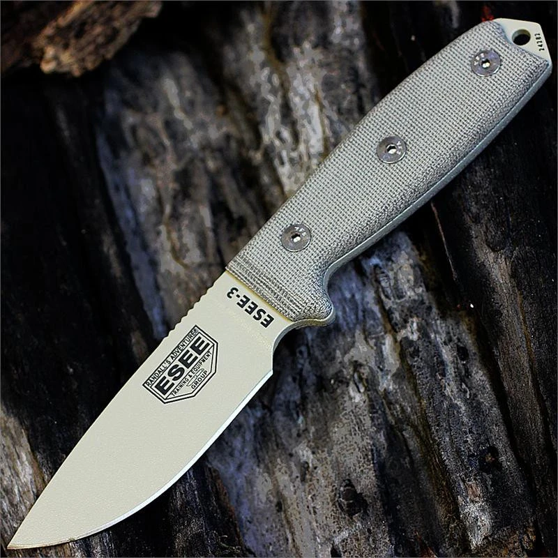 The ESEE-3 (ESEE-3P-MB-DT) shown with its 3.88-inch 1095 drop point blade in a Desert Tan finish and flat grind, tan Micarta handle scales, and its injection-molded OD Green plastic sheath with MOLLE back mounting.