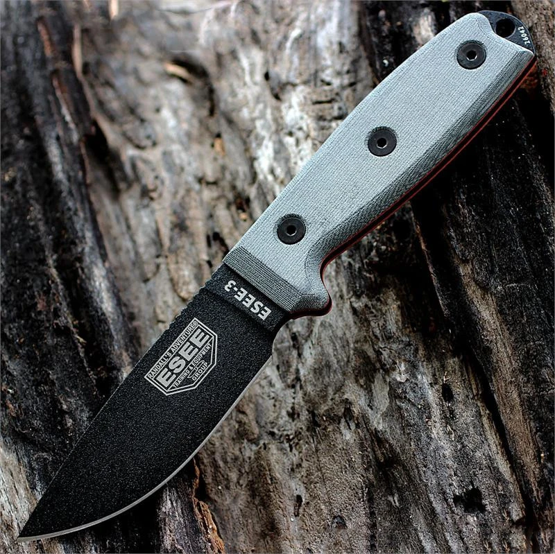 The ESEE-3 (ESEE-3PM-MB-B) shown with its 3.88-inch 1095 black drop point blade and flat grind, gray Micarta handle scales with a modified pommel, and its injection-molded plastic sheath with MOLLE back mounting.
