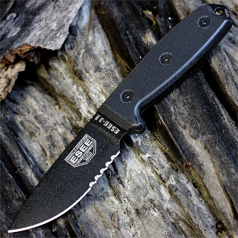 The ESEE-3MIL (ESEE-3MIL-S-BLK) shown with its 3.88-inch 1095 black part serrated drop point blade and flat grind, black G-10 handle with integrated glass breaker, and its injection-molded black plastic sheath with black MOLLE back mounting.