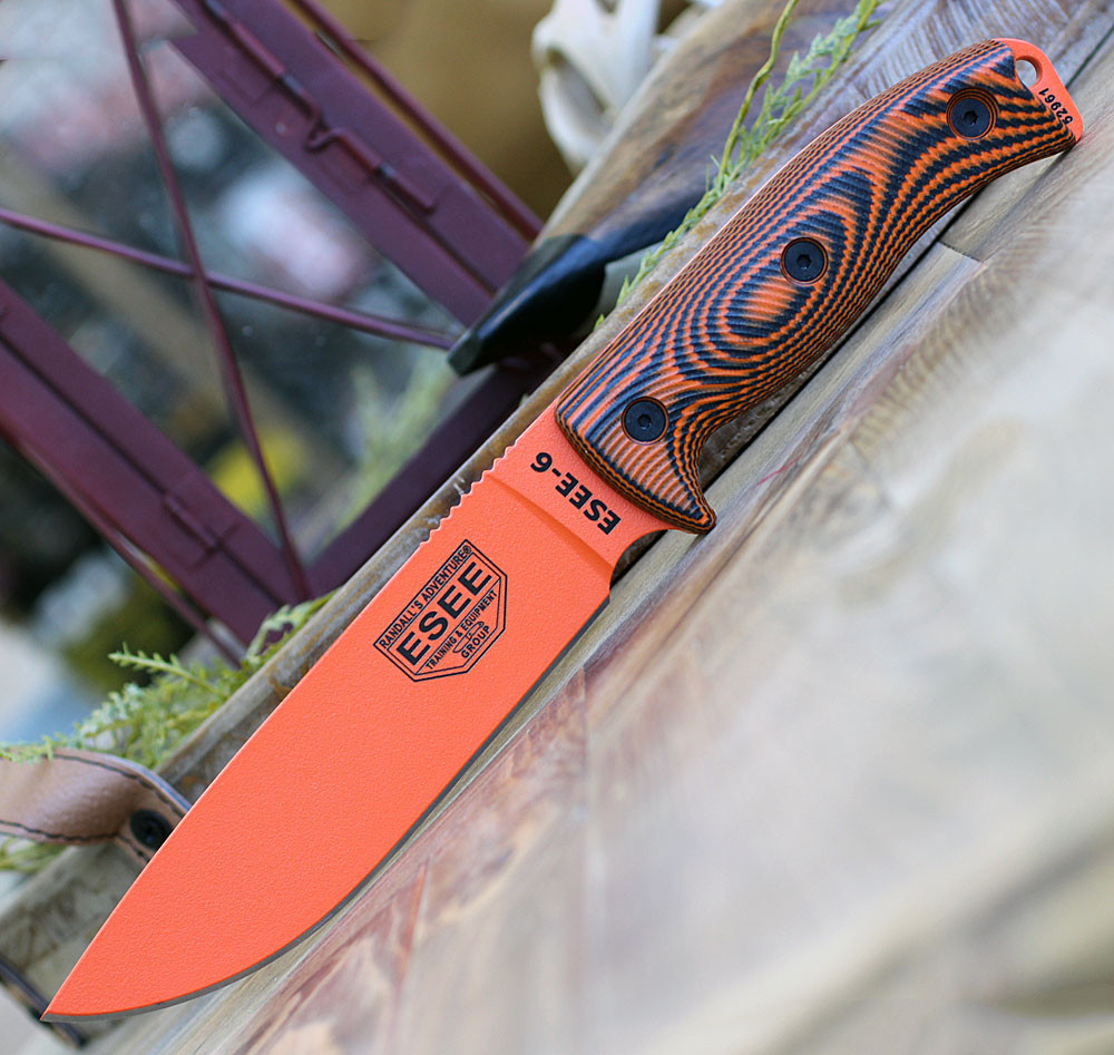 The ESEE-6 3D Handle (6POR-006) shown with its 6.50-inch 1095 plain edge drop point blade in an Orange finish and flat grind, 3D orange and black G-10 handle scales with finger choil, and its injection-molded black plastic sheath.