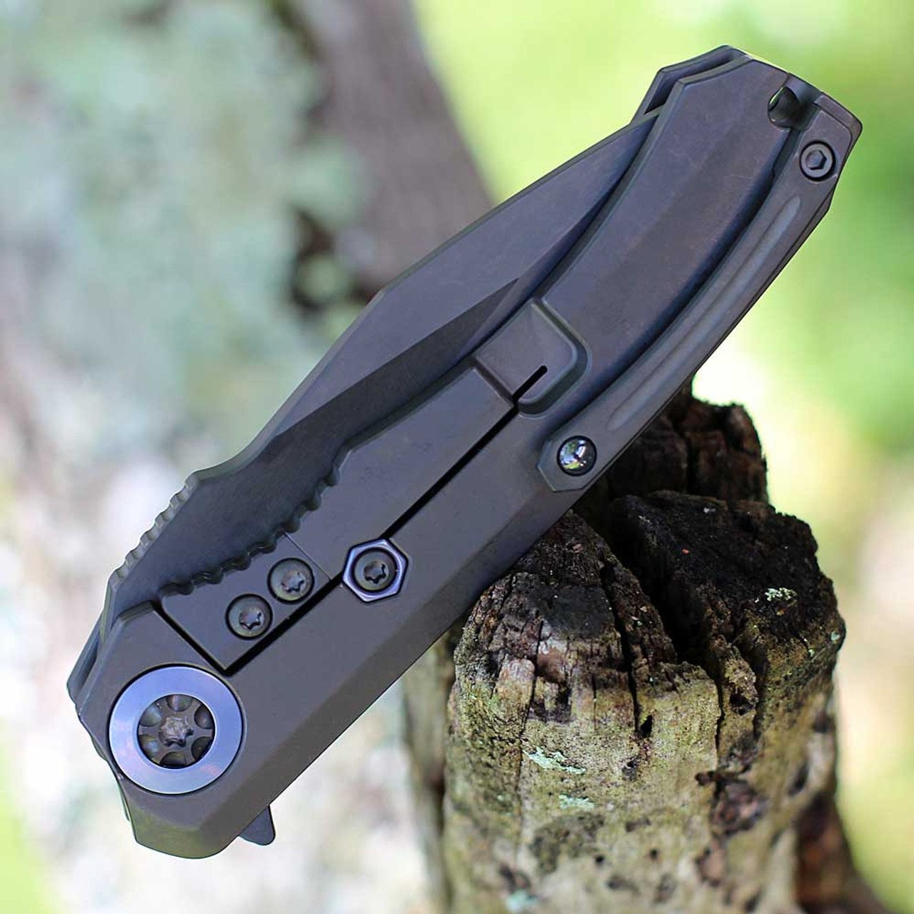 Heretic Knives Wraith Manual Flipper (H001-6B-BLUTI) 3.62" Magancut Clip Point Battleworn Black Part Serrated Blade, Titanium Chassis, Carbon Fiber Front Scale with Blue Titanium Accents, Battleworn Black Titanium Back