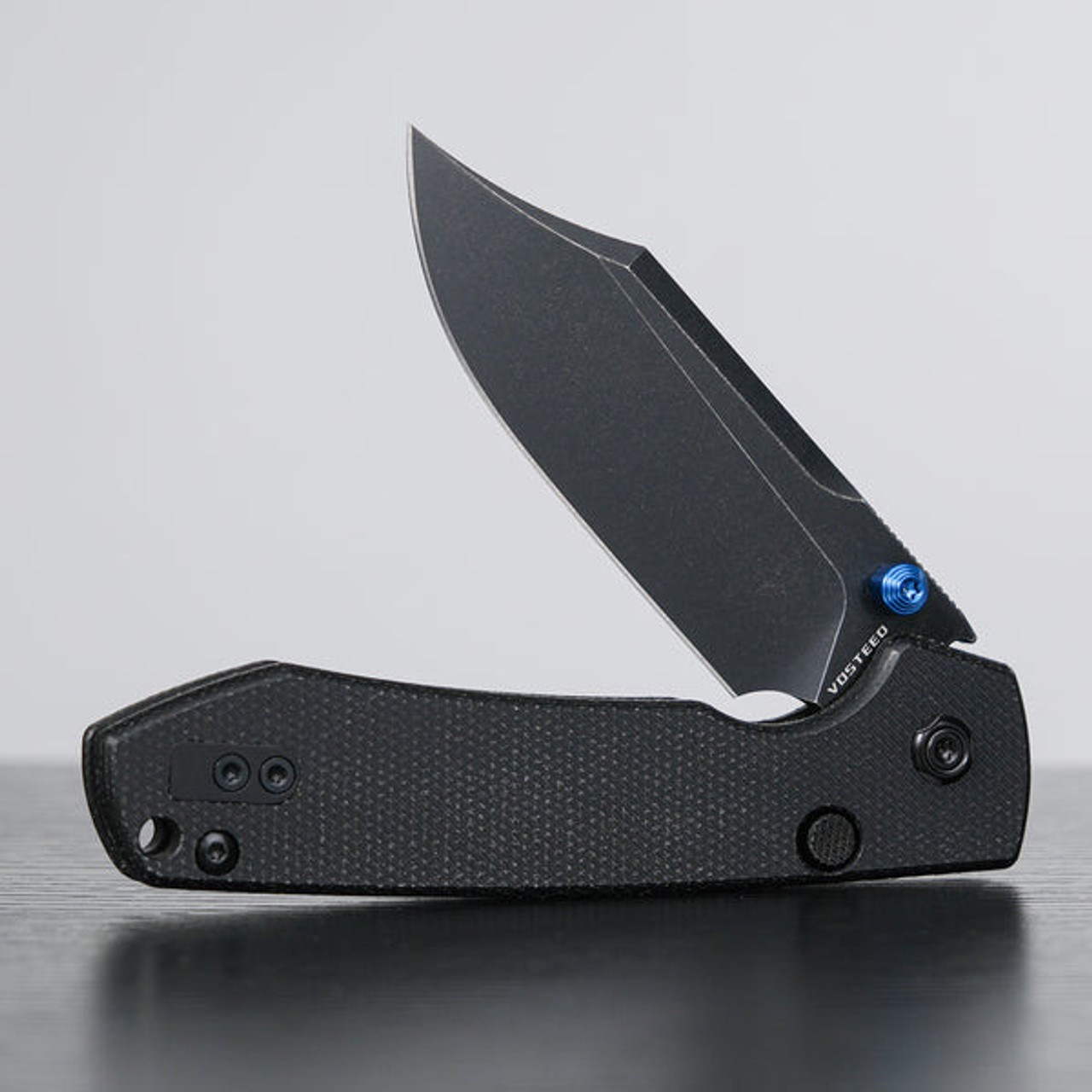 Vosteed Raccoon® Top Liner Lock (A2910) 3.25" Sandvik 14C28N Black Stonewash/Plain Bowie Blade, Blue Thumb Stud, Black Micarta Handle
