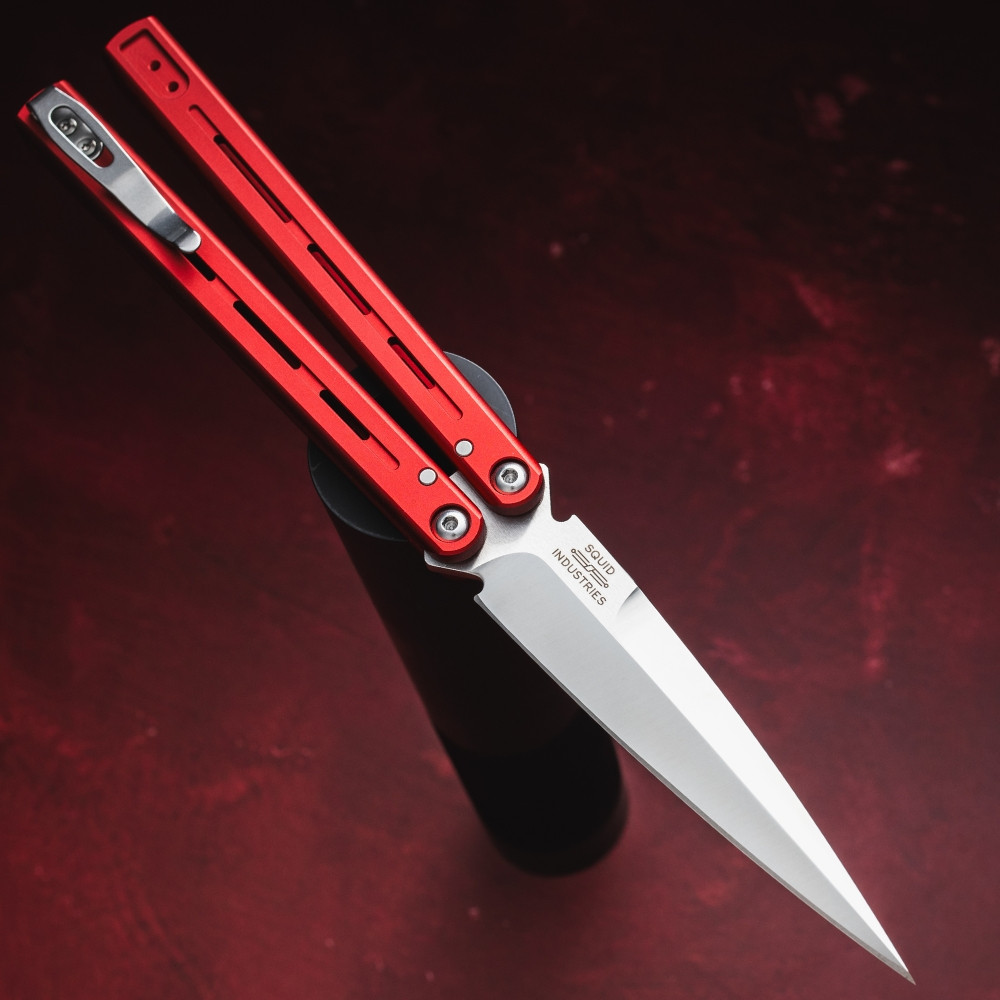 Pro-Tech Flyfather 2 FF2101-RED shown at an angled profile on a dark red background, displaying the red aluminum channel handles and satin 154CM blade from a side perspective. The slim channel handle profile and satin hardware are clearly visible from this angle.