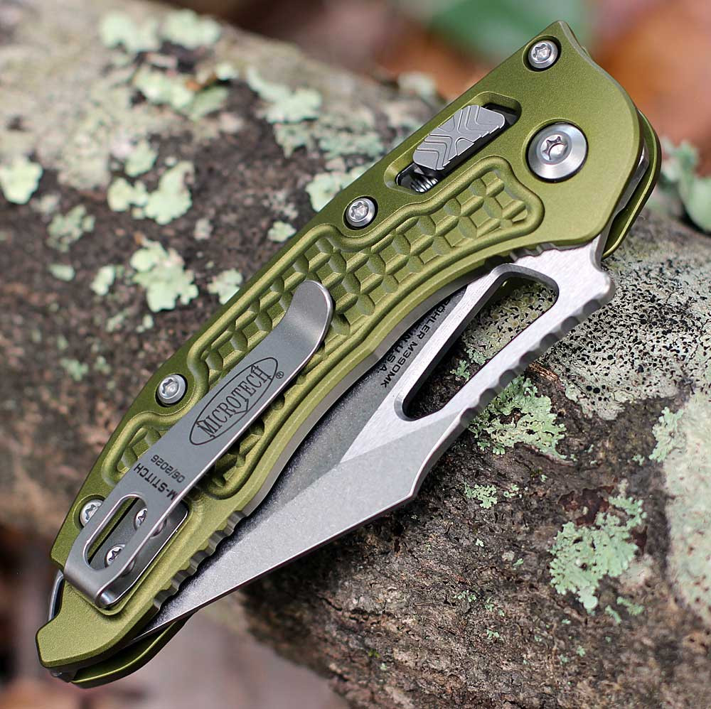 Microtech Mini Stitch RAM-LOK 169MRL-10FROD spine view — OD green aluminum handle, deep-carry titanium clip, Microtech and M-Stitch markings visible