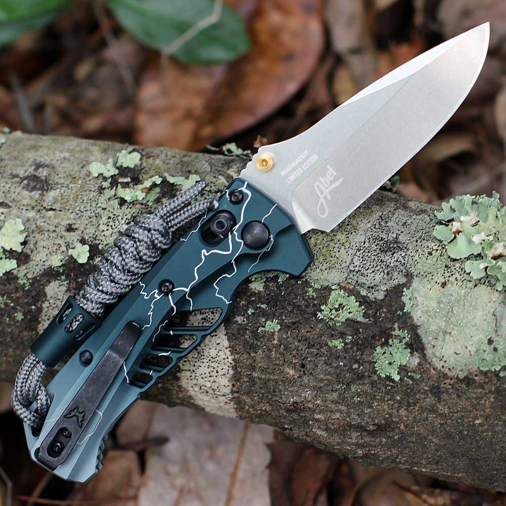 Benchmade Mini Adira 18065-ABEL1 open — CPM MagnaCut 3.21 in satin drop point blade, Abel Dark Waters teal handle, Abel Limited Edition blade stamp