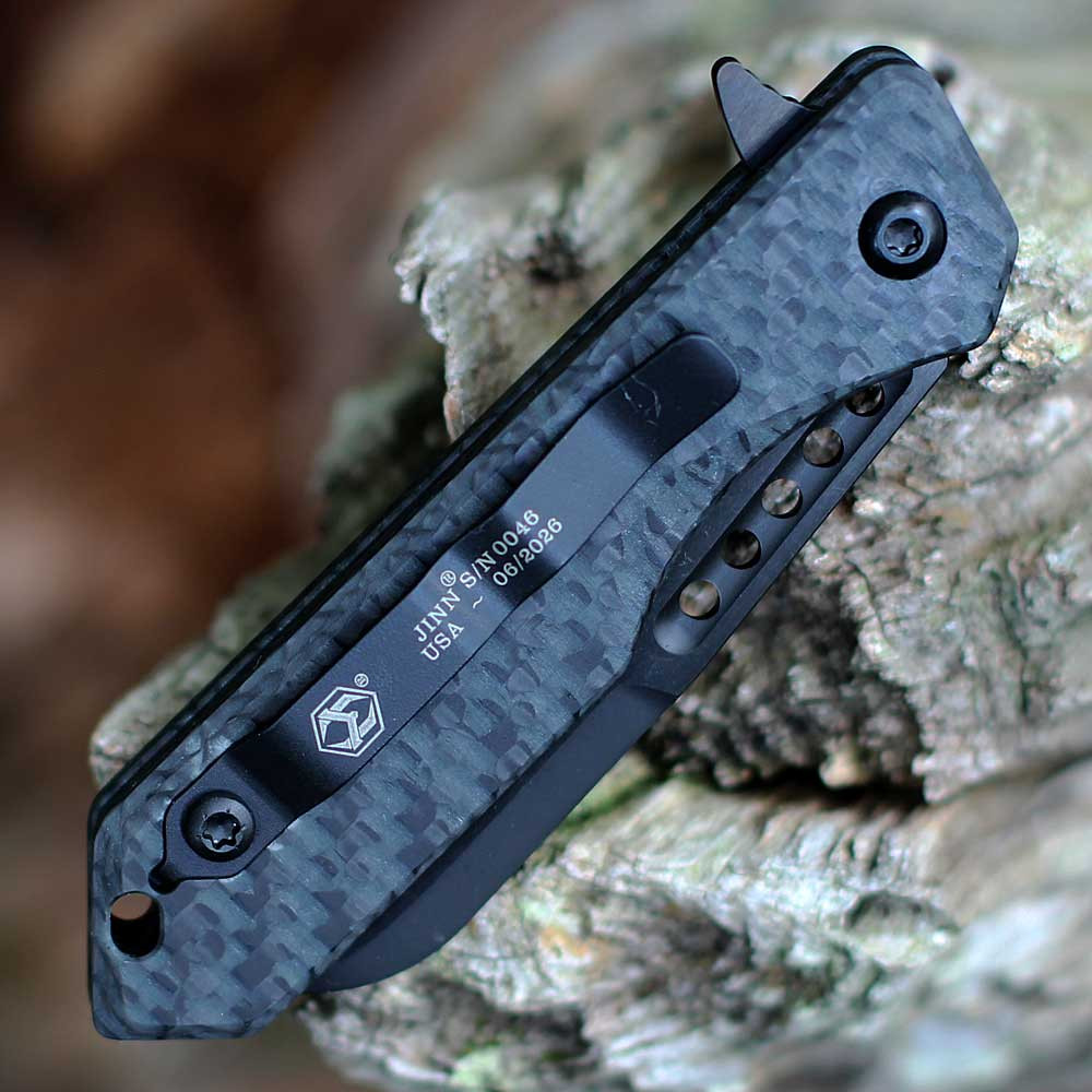 Heretic Knives Jinn Manual H213-6A-GLOCF spine — serialized USA-made, JINN serial number stamp, glow carbon fiber handle, black hardware