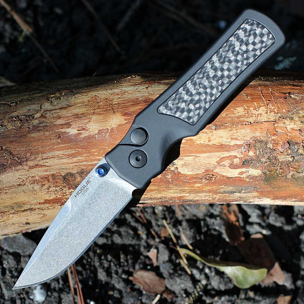 Hogue Saxum 24691-LIM open — CPM MagnaMax stone tumbled drop point blade, matte black aluminum carbon fiber handle, Button Lock