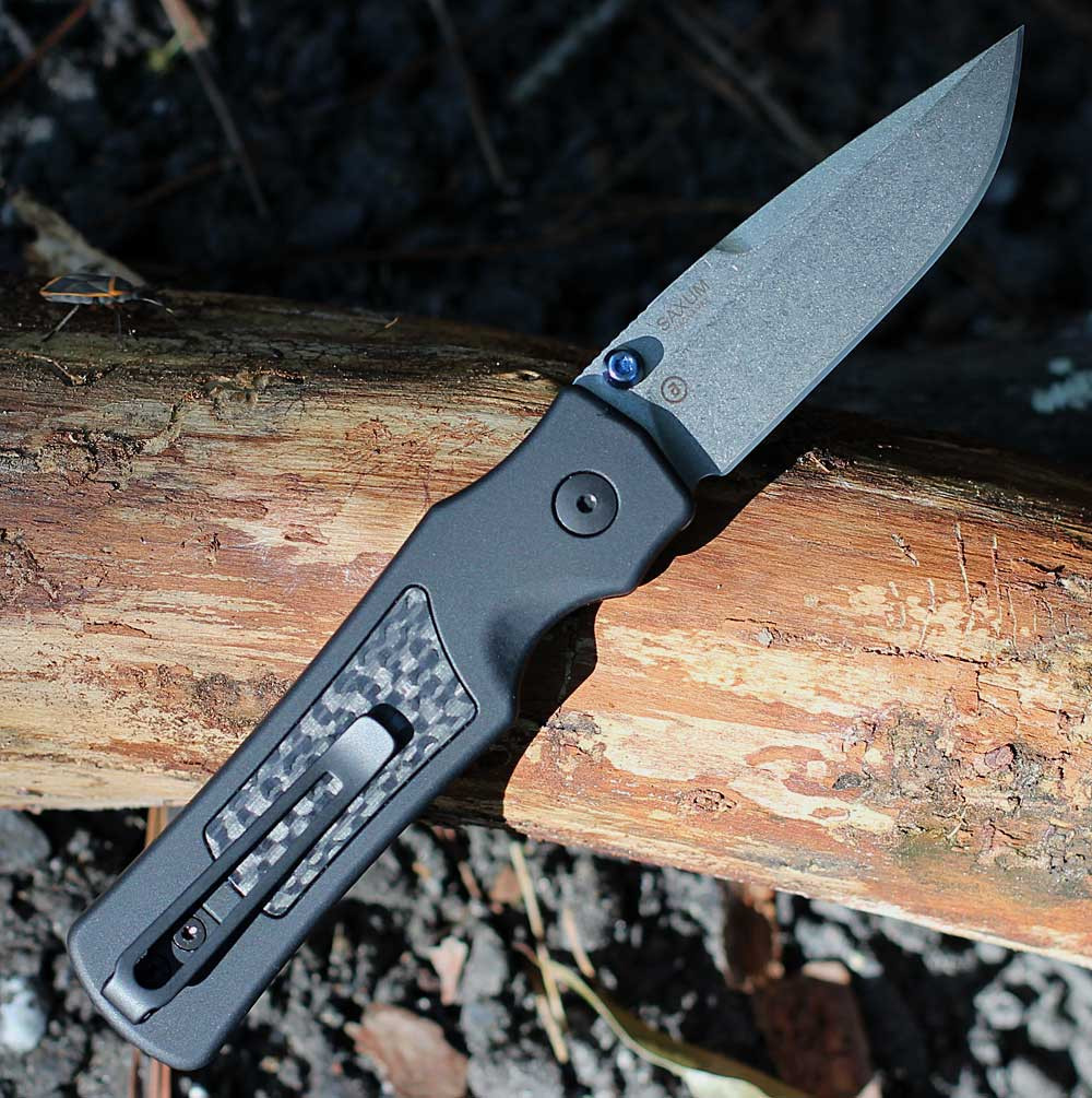 Hogue Saxum 24691-LIM open — CPM MagnaMax stone tumbled drop point blade, matte black aluminum carbon fiber handle, Button Lock