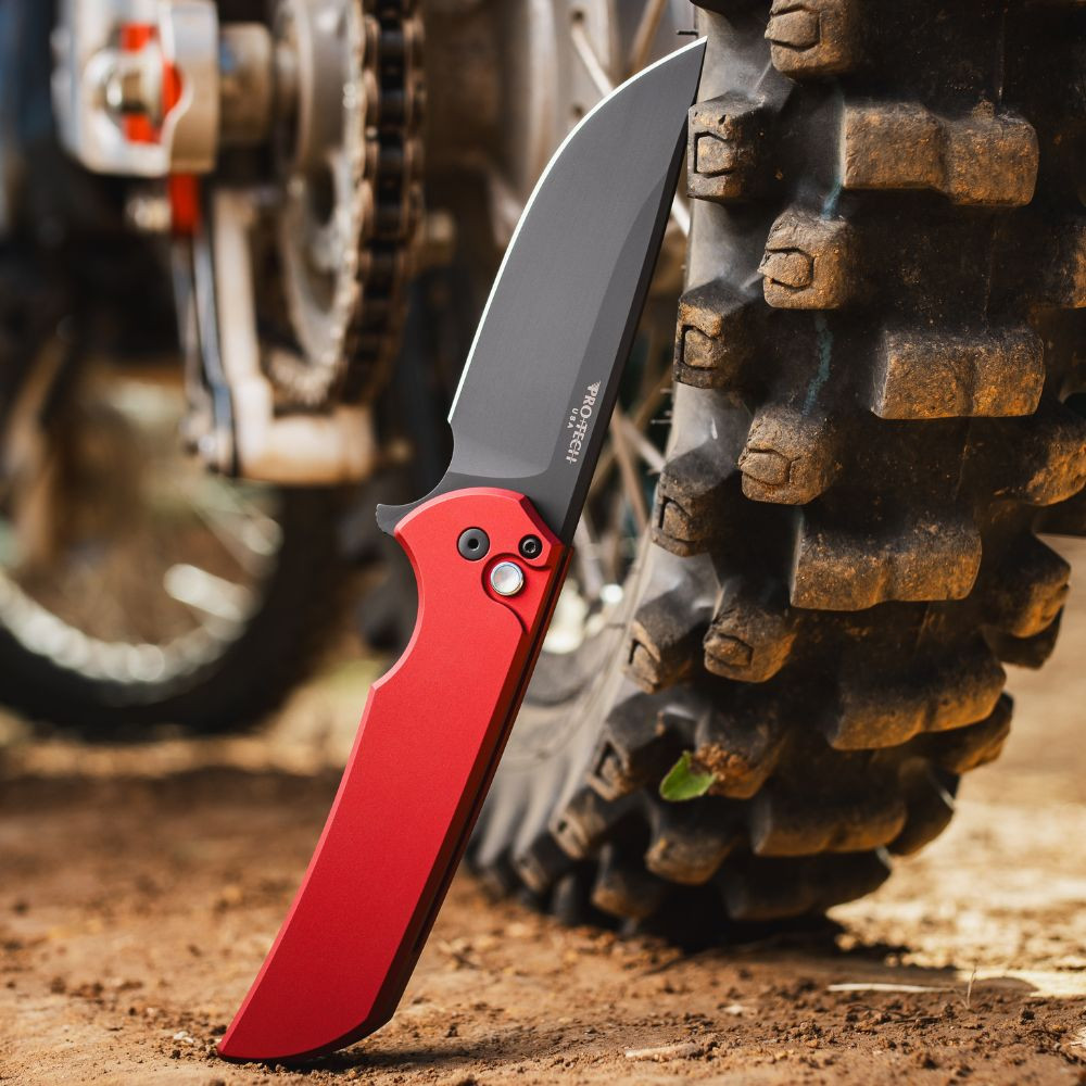 Pro-Tech Mordax Limited Edition MX103-LTD RED — open, DLC black CPM-MagnaCut blade extended, solid red aluminum handle, outdoor setting