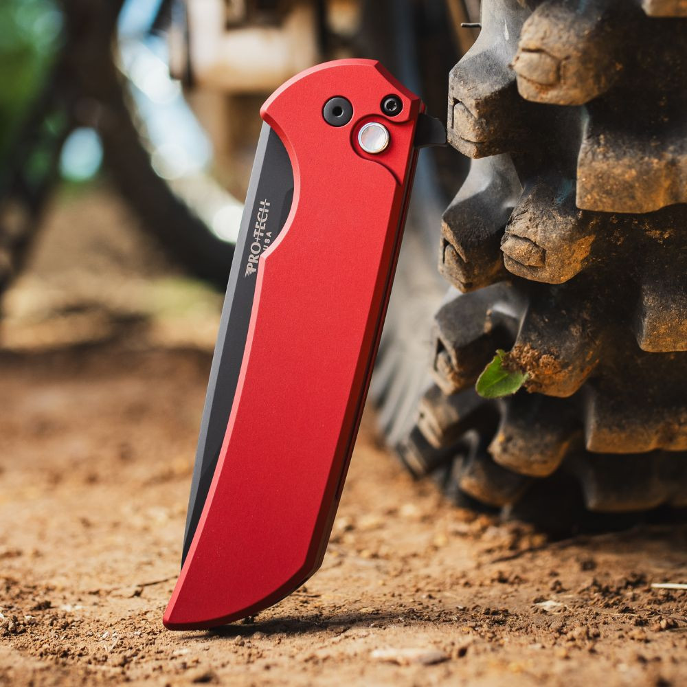 Pro-Tech Mordax Limited Edition MX103-LTD RED — closed, solid red aluminum handle and DLC black deep carry clip, outdoor background