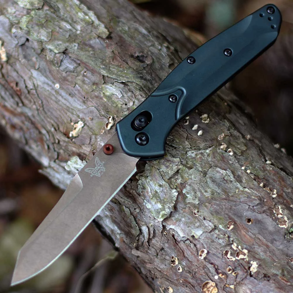 The Benchmade Seasonal 940 Osborne 940FE-2601 is shown open, featuring a 3.40-inch Flat Dark Earth Battlewash PVD-coated CPM-S90V reverse tanto blade extending from a Taiga Green 6061-T6 aluminum handle with Burnt Copper barrel spacers, dual thumb studs, and AXIS Lock mechanism.