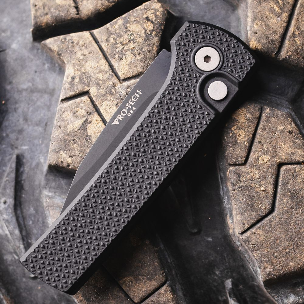 Pro-Tech Scapegoat Compact Auto RCS1106 — closed, carbide textured black aluminum handle and DLC black deep carry clip, cracked earth background
