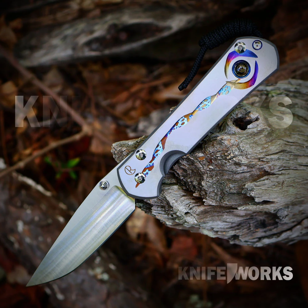 A Chris Reeve Large Sebenza 31 Unique Graphic folding knife shown with the blade deployed, highlighting the CPM-MagnaCut drop point blade alongside the freehand-milled titanium handle graphic, silver hardware, and genuine Citrine thumb stud.