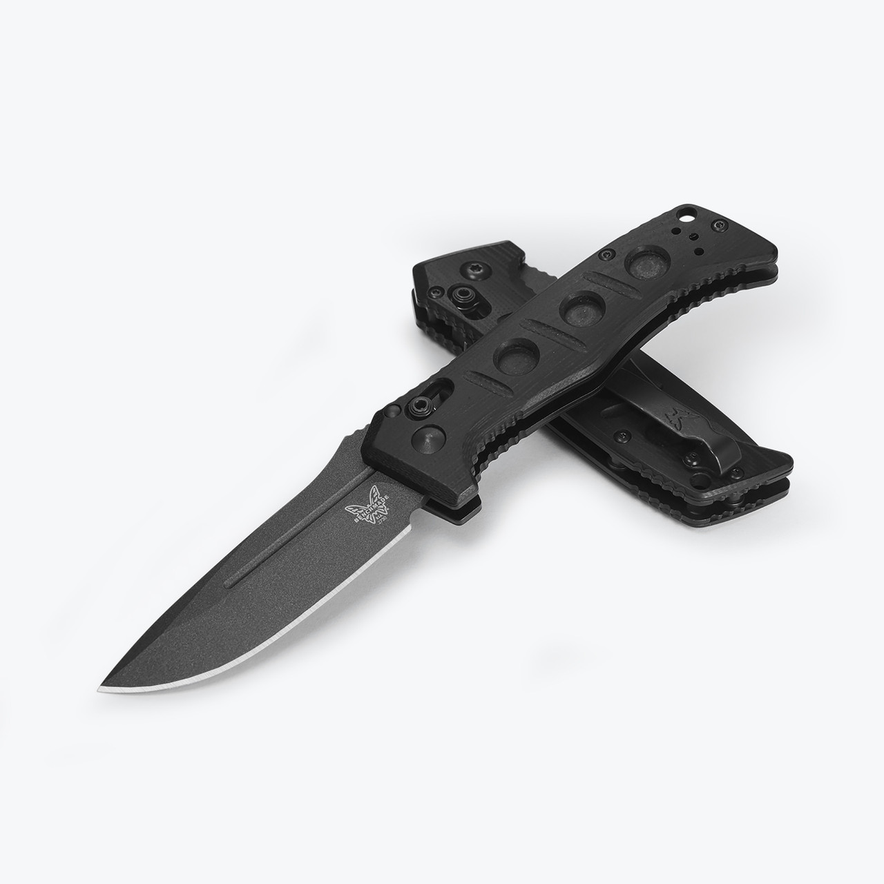 A Benchmade Mini Auto Adamas folding knife shown with the blade deployed, highlighting the MagnaCut Tungsten Gray Cerakote drop-point blade alongside the black G10 handle and integrated spine safety switch.