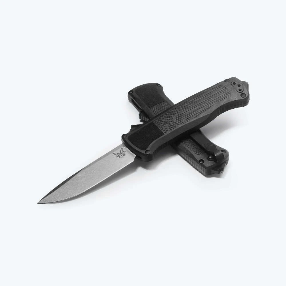 A Benchmade Shootout Black Drop-Point out-the-front automatic knife shown with the blade deployed, highlighting the S30V stonewash drop-point blade alongside the black Grivory handle and hardened carbide glass punch in the pommel.
