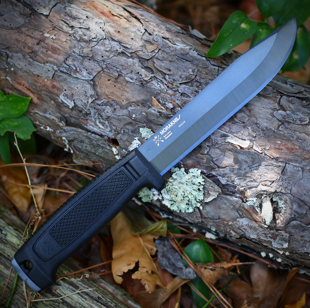 The Morakniv Mörkret Black Blade (C) (14701) shown with its 153 mm (6.0") full-tang 100Cr6 carbon steel blade in a black DLC coating, Power Touch Grip handle with finger guard and lanyard hole, and its ambidextrous black Click-On sheath.