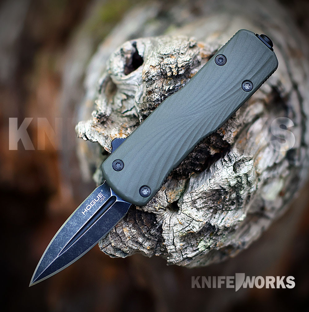 The Hogue Micro Counterstrike (34701) automatic OTF knife shown with its 1.95-inch double edge CPM-MagnaCut blade in a black stonewash finish, ornately milled 6061-T6 anodized aluminum case, OD Green glass fiber reinforced polymer cover, and deep carry reversible pocket clip.