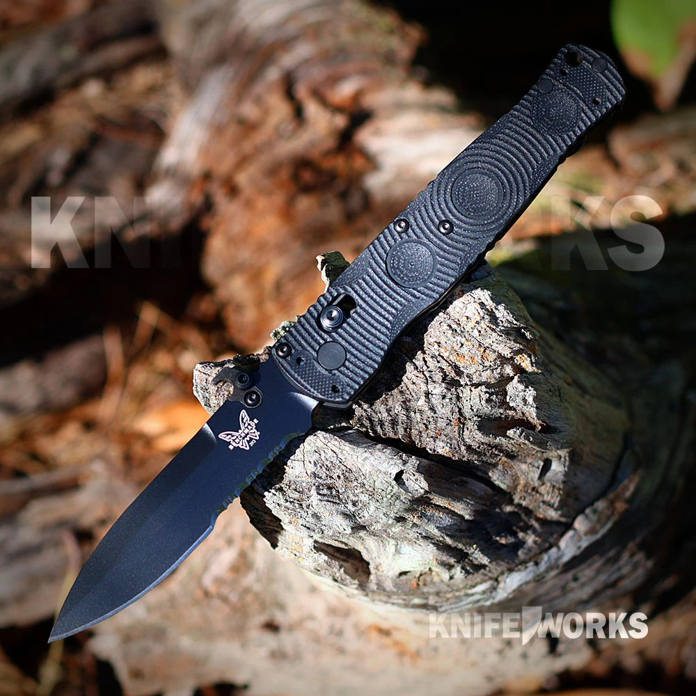 The Benchmade Mini SOCP Folder open, showing its 3.76-inch Graphite Black Cerakote CPM-S30V spear-point blade, thumb disk and thumb stud, pocket deployment hook, AXIS Lock, textured black G-10 scales, and finger-ring carry hardware.