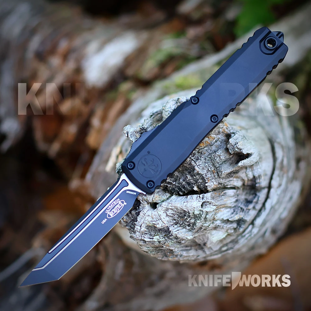 The Microtech Ultratech Gen III ZBP is shown with its black tanto blade deployed from the front of the black aluminum handle. The thumb slide, Torx screws, and pocket clip are visible.