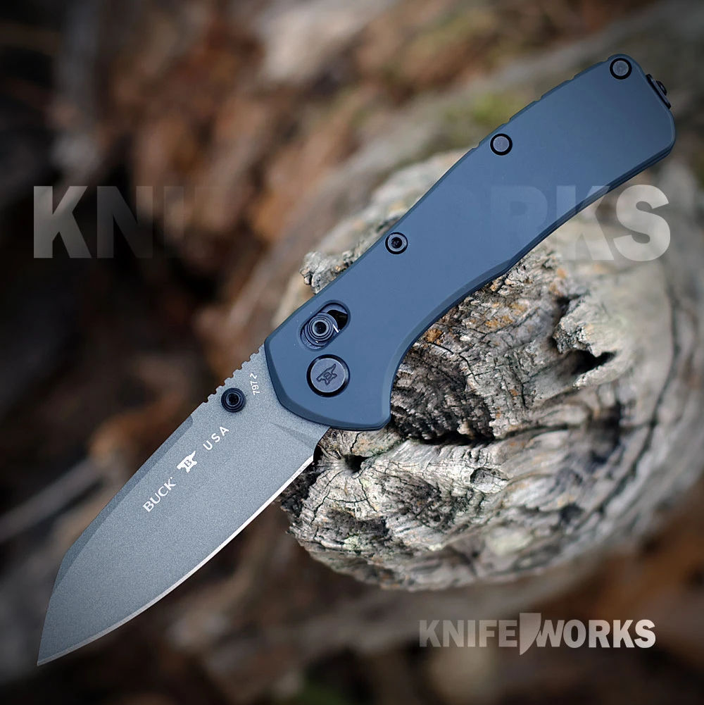 The Buck Range Ops Elite 0797BLS is shown open, featuring a gray Cerakote CPM MagnaCut reverse tanto blade, crossbar lock, and blue aluminum handle with a deep-carry pocket clip.