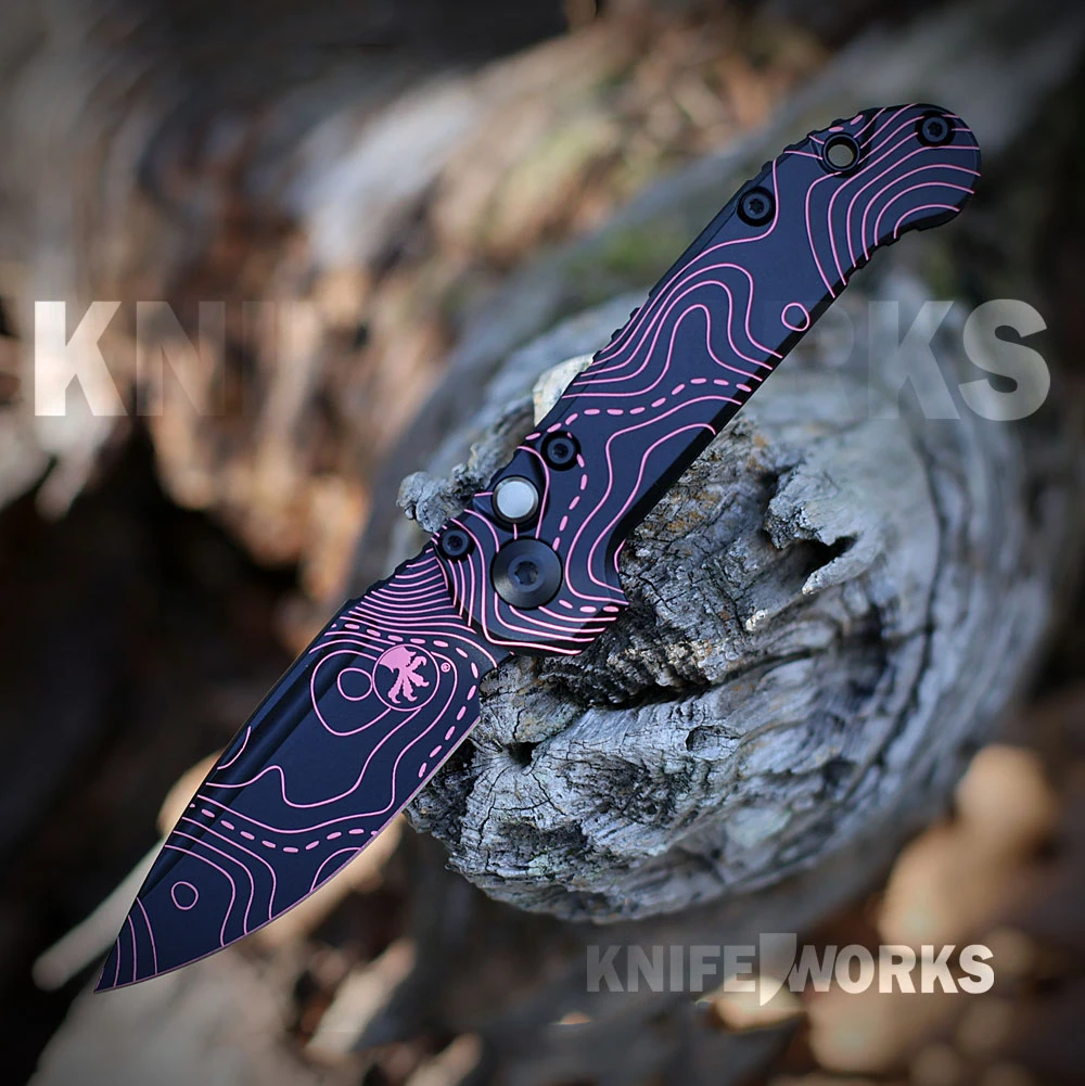 The Microtech LUDT Gen III 1135S-1-TPBKPKCS is shown open, featuring its 3.42-inch M390MK single-edge blade and smooth 6061-T6 aluminum handle both finished in a matching Topographic Black and Pink camo laser-etched design.