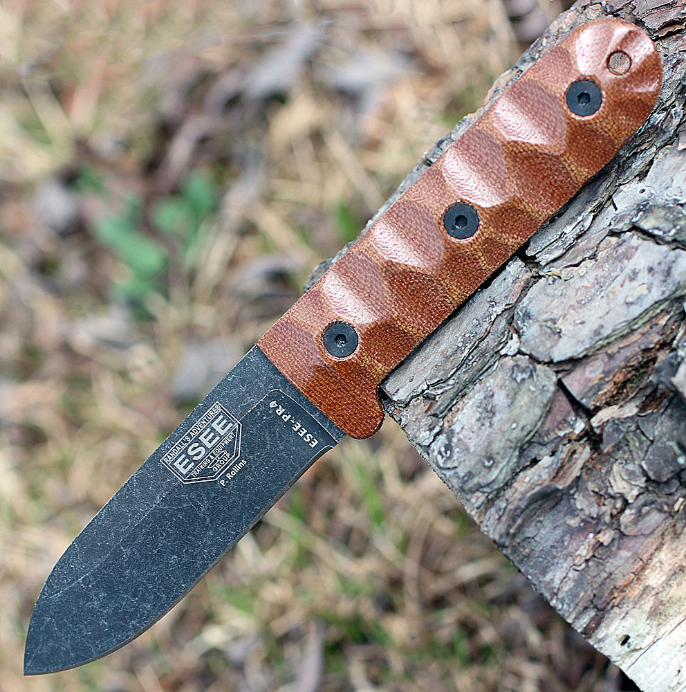The ESEE Camp-Lore PR4 (ESEE-PR4-BO) shown with its 4.19-inch 1095 full tang plain edge spear point blade in a tumbled black finish and flat grind, brown sculptured Micarta handle, and its heavy-duty brown leather belt sheath.