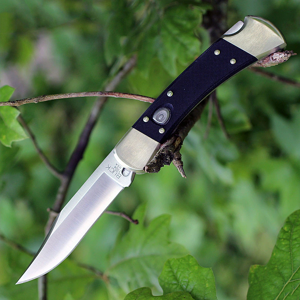 A Buck 110 Auto Elite push-button automatic knife shown with the blade deployed alongside its genuine black leather friction-fit sheath, highlighting the CPM-MagnaCut clip point blade and black G-10 handle with nickel silver bolsters.