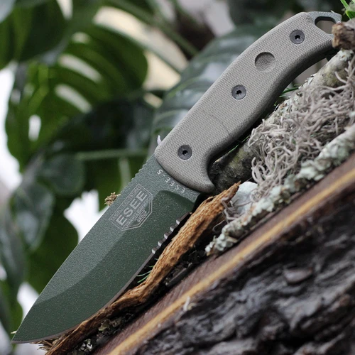 The ESEE-5 (ESEE-5S-KO-OD) shown with its 5.25-inch 1095 saber ground part serrated drop point blade in an OD Green finish, sharpened glass breaker pommel, fire-making bow drill divot, and tan Micarta handle scales. This is a knife-only listing — no sheath is included.