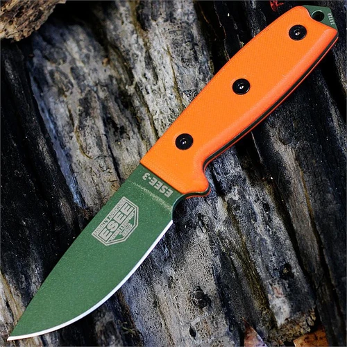 The ESEE-3 (ESEE-3P-OD) shown with its 3.88-inch 1095 plain edge drop point blade in an OD Green finish and flat grind, orange G-10 handle scales, and its injection-molded black plastic sheath.