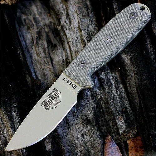 The ESEE-3 (ESEE-3PM-MB-DT) shown with its 3.88-inch 1095 plain edge drop point blade in a Desert Tan finish and flat grind, tan Micarta handle with a modified pommel, and its injection-molded OD Green plastic sheath with MOLLE back mounting.