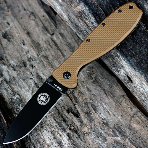 The ESEE Zancudo (BRKR1CBB) shown with its 2.94-inch AUS-8 drop point blade in a black finish and flat grind, Coyote Brown polymer handle with steel frame lock, and reversible pocket clip for tip-up or tip-down carry.