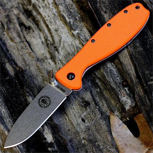 The ESEE Zancudo (BRKR1OR) shown with its 2.94-inch AUS-8 drop point blade in a stonewash finish and flat grind, orange polymer handle with steel frame lock, and reversible pocket clip for tip-up or tip-down carry.