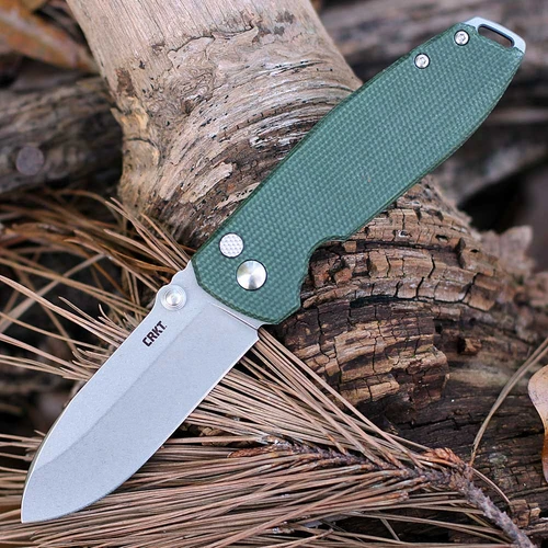 The CRKT Squid XM (2495GR) shown with its 2.95-inch D2 stonewashed drop point blade, hybrid handle pairing a green Micarta front scale with a stonewashed stainless steel frame-lock back, and its low-profile deep-carry pocket clip. The flipper tab and IKBS ball bearing pivot are visible along the spine of this fast-deploying EDC folder.