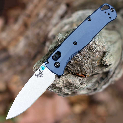 The Benchmade Bugout 535SL-13 is shown open, featuring a 3.24-inch satin-finished CPM-S90V drop point blade extending from a Crushed Silver Crater Blue anodized 6061-T6 aluminum handle with dual thumb studs and AXIS Lock mechanism.