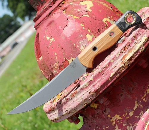 The Benchmade Meatcrafter 4050-02 is shown, featuring a 6.14-inch polished stonewashed CPM-154 trailing point full-tang blade extending from a Maple Valley Richlite composite handle with stainless steel hardware and gray Boltaron belt sheath.