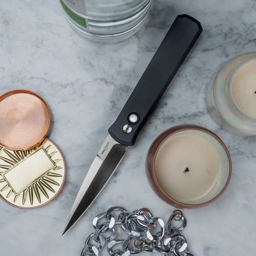 The Pro-Tech Godfather knife is a distinguished piece, inspired by the classic Italian stiletto design. This automatic knife combines elegance, functionality, and precision, making it a sought-after item for collectors and enthusiasts alike.

Key Features
Blade
Material: The blade is crafted from 154CM stainless steel, known for its excellent edge retention and corrosion resistance.

Finish: It features a satin finish that enhances its sleek appearance while offering some resistance to glare.

Length: The 4-inch blade provides a perfect balance between functionality and portability, making it versatile for various tasks.

Handle
Material: The handle is made from black anodized aluminum, offering a lightweight yet sturdy grip.

Design: It is enhanced with a Mother of Pearl (MOP) inlay button, adding a touch of luxury and sophistication.

Mechanism
Automatic Deployment: The Godfather knife utilizes an automatic opening mechanism, providing quick and seamless blade deployment with the push of a button.

Design and Aesthetics
The Pro-Tech Godfather embodies the elegance of traditional Italian knife design, with a modern twist. Its sleek profile and refined details make it not only a functional tool but also a statement piece. The combination of the satin blade and black aluminum handle with the MOP inlay sets it apart as a luxurious and eye-catching accessory.

Practical Uses
While the Godfather is a collector’s favorite, it also serves practical purposes:

Everyday Carry (EDC): Its size and automatic mechanism make it ideal for everyday tasks.

Self-Defense: The quick deployment and sharp blade ensure it's ready for defensive use if needed.

Collection: For knife enthusiasts, its design and craftsmanship make it a valuable addition to any collection.

Conclusion
The Pro-Tech Godfather knife is a masterpiece of design and functionality. Its Italian-inspired aesthetics, combined with modern materials and mechanisms, make it a versatile and desirable tool. Whether for practical use or as a collector's item, this knife stands as a testament to the artistry and ingenuity of knife-making.