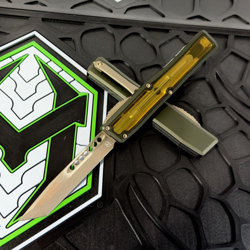 Heretic Nyx double-action OTF knife (H015-7A-GRN-ULTEM) shown against a plain background, featuring a green Ultem polymer handle with a stepped fire button, machined pocket clip, low-profile glass breaker at the rear of the handle, and a 3.62-inch CPM MagnaCut blade extended from the front of the housing.