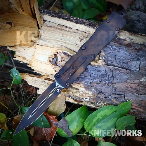 A Microtech Dirac Delta D/E Signature Series Plague Outbreak out-the-front automatic knife shown with the blade deployed, highlighting the M390MK plain double-edged blade alongside the top cover firing button and Signature Series finish.