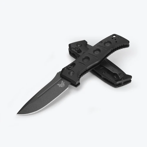 A Benchmade Mini Auto Adamas folding knife shown with the blade deployed, highlighting the MagnaCut Tungsten Gray Cerakote drop-point blade alongside the black G10 handle and integrated spine safety switch.