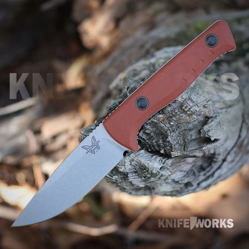 The Benchmade SlipRidge Fixed is shown with its satin drop-point blade and Rust Orange G10 handle with a finger choil. Its OD green Boltaron sheath is shown alongside.