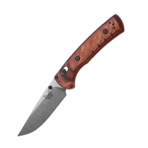 The Benchmade SlipRidge™ folder (15090) shown with its 3.5-inch CPM MagnaCut stainless modified clip-point blade in a satin finish, stabilized dark brown wood handle scales, and its deep carry black pocket clip. The AXIS Lock bar and contoured pinch points on the spine are visible, along with the full liner construction underneath the removable wood scales.
