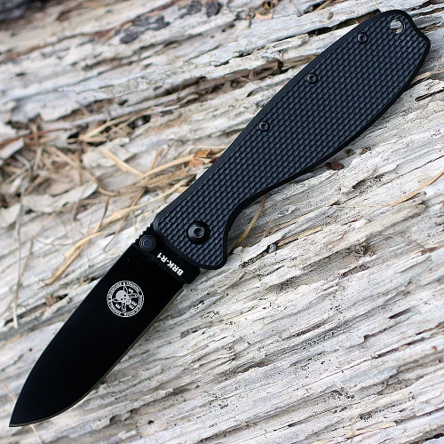 The ESEE Zancudo (BRKR2B) shown with its 2.94-inch D2 drop point blade in a black finish and flat grind, black polymer handle with steel frame lock, and reversible pocket clip for tip-up or tip-down carry.
