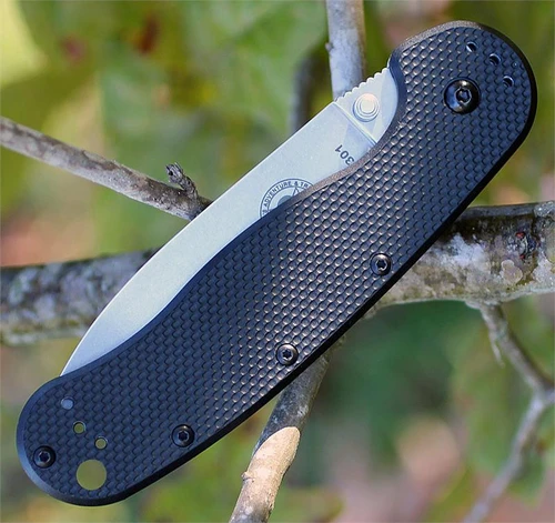 The ESEE Avispa (BRK1302B) shown with its 3.50-inch D2 drop point blade in a black finish and flat grind, black polymer handle with steel frame lock, and pocket clip for tip-up or tip-down carry.