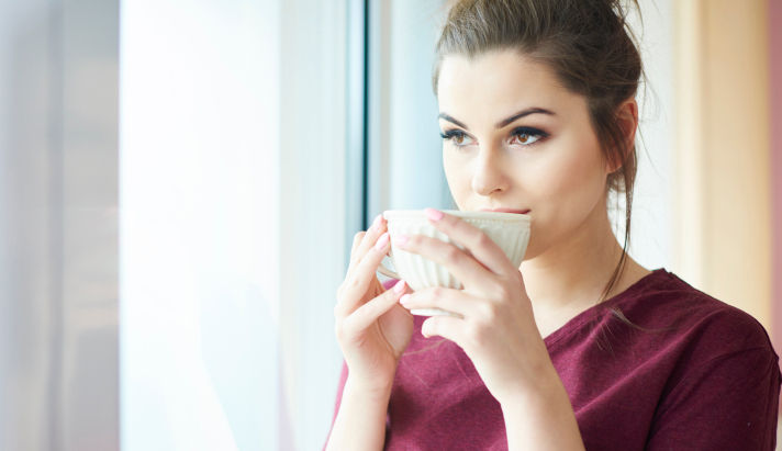 Woman enjoying a cup of tea by a window