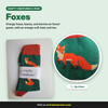 Green crew socks with orange foxes, leaves, and berries and an orange cuff, heel, and toe