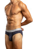 Man standing wearing a pair of Jack Adams peacoat blue Zen Horizontal Fly Briefs (profile view) in front of a white background.